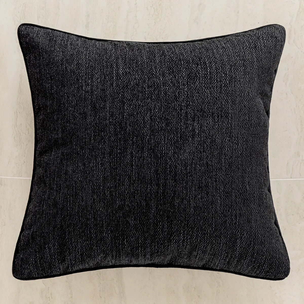 Un coussin décoratif noir texturé.