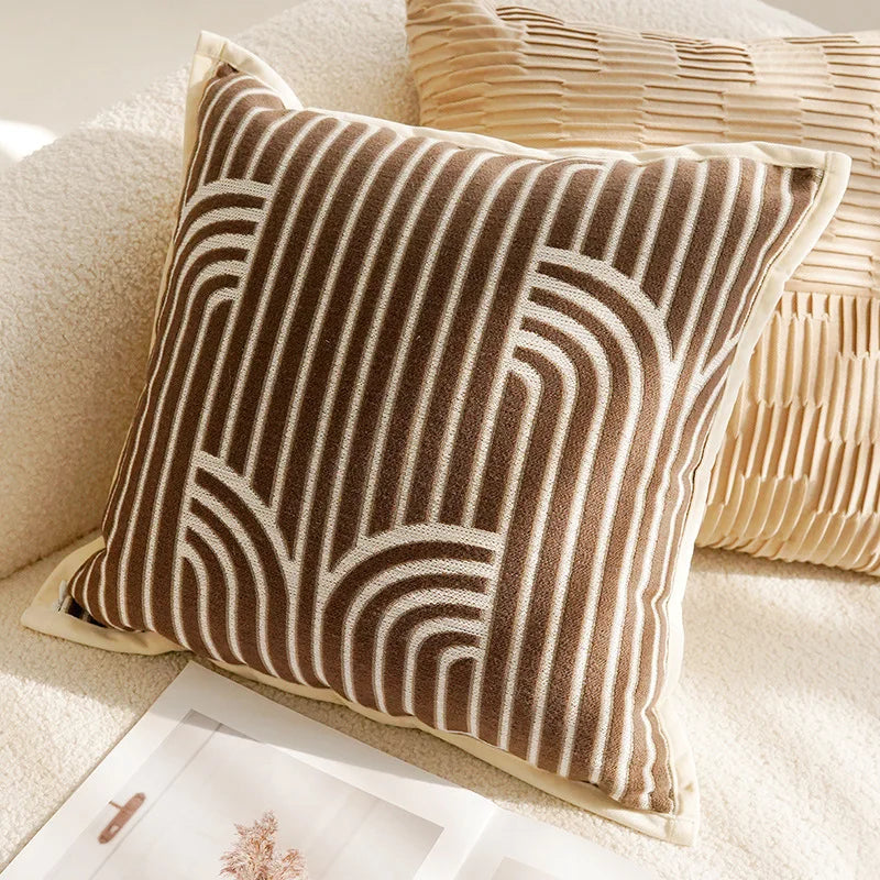 Un coussin décoratif en velours côtelé marron et beige, présentant un motif géométrique élégant et sophistiqué, offrant une touche de style et de confort à l'ameublement.