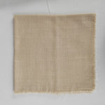 Couverture de luxe en lin beige avec des franges sur les bords, idéale pour la décoration d'intérieur.