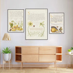 Des illustrations botaniques colorées et détaillées encadrées qui décorent le mur au-dessus d'un meuble de rangement en bois, créant une atmosphère chaleureuse et naturelle dans cette pièce.
