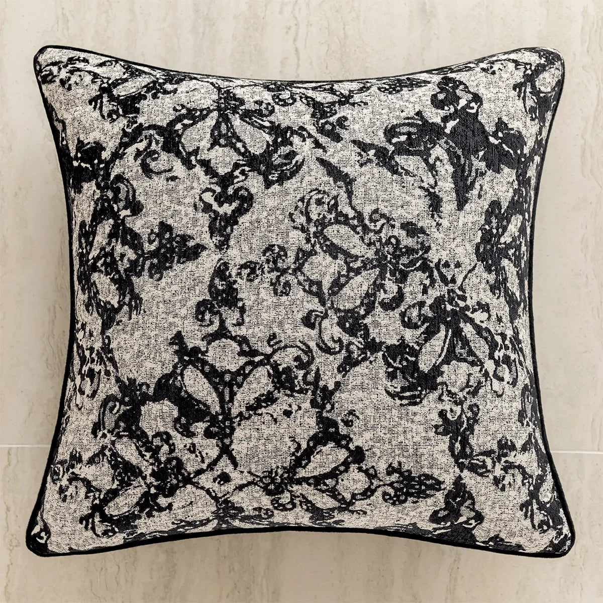 Un oreiller décoratif aux motifs floraux abstraits en noir et blanc, créant un design élégant et graphique.