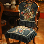 Chaise élégante recouverte de motifs floraux vintage sur un fond sombre, créant une ambiance chaleureuse et vintage dans la pièce.
