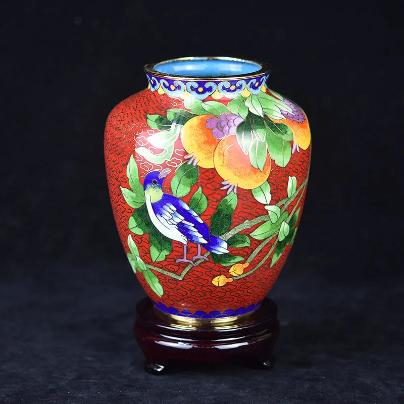 Magnifique vase décoratif en céramique émaillée ornée de fleurs et d'un oiseau stylisé sur un fond rouge vif.