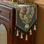 Superbe tenture murale de style vintage ornée de fleurs multicolores et de glands décoratifs, apportant une touche d'élégance et de charme à cette pièce.