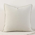 Coussin décoratif blanc avec des bords lisses et un motif de texture sur la surface.