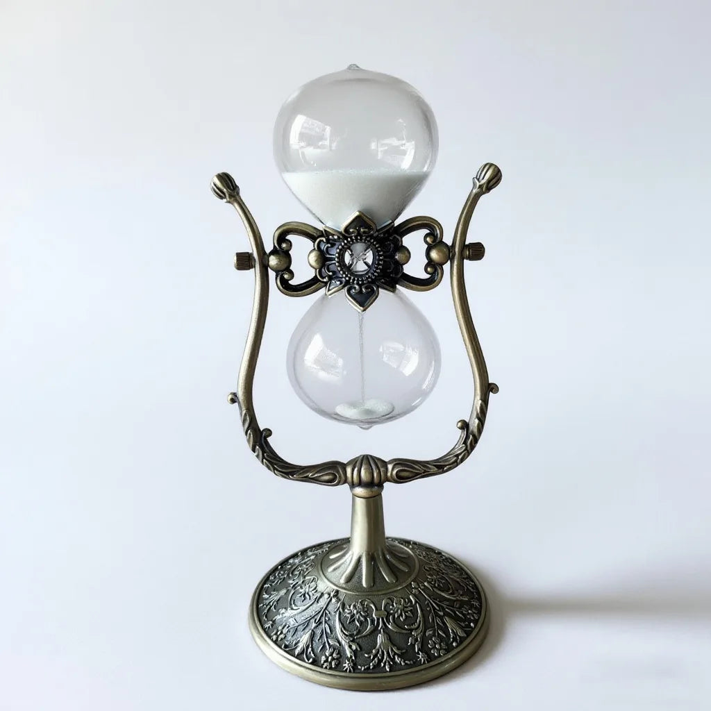 Sablier décoratif en forme de U en métal bronze antique et verre sur un bureau