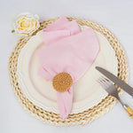 Une belle assiette avec une serviette rose, une rose blanche et des couverts sur un set de table en fibres naturelles.