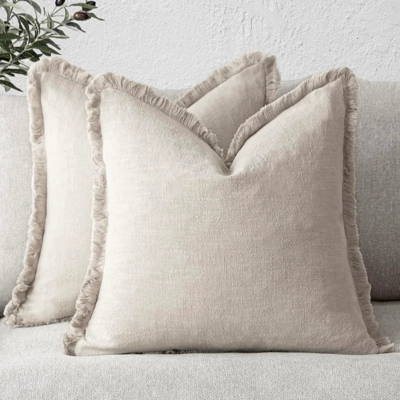Ensemble de coussins décoratifs moelleux avec des bordures texturées, créant une ambiance confortable et élégante dans le salon.