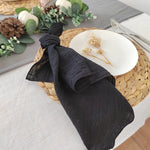 Une nappe en fibres naturelles avec un motif en tressage, servie avec un plat blanc décoré de fleurs séchées.