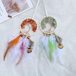 Des attrape-rêves colorés avec des perles, des plumes et des motifs d'arbre de vie en cristal.