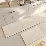Deux tapis antidérapants dans une cuisine blanche et épurée, créant une surface confortable et minimaliste.