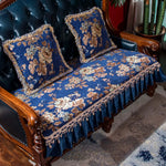 Ce canapé à trois places orné d'un motif floral bleu et doré avec franges est un élément d'ameublement élégant et décoratif.