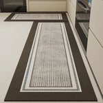 Deux tapis de cuisine allongés de différentes tailles avec des motifs géométriques blancs et noirs dans un intérieur moderne.