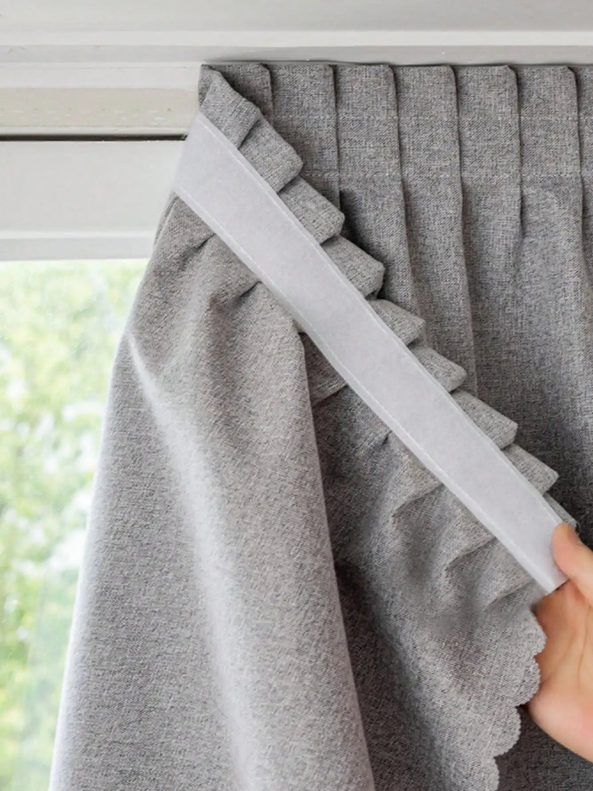 Rideau gris élégant avec plis et garniture décorative, idéal pour embellir une fenêtre et offrir une ambiance chaleureuse et moderne à votre intérieur. Ce rideau s'adapte facilement à différents styles de décoration et est parfait pour contrôler la lumière et préserver votre intimité.