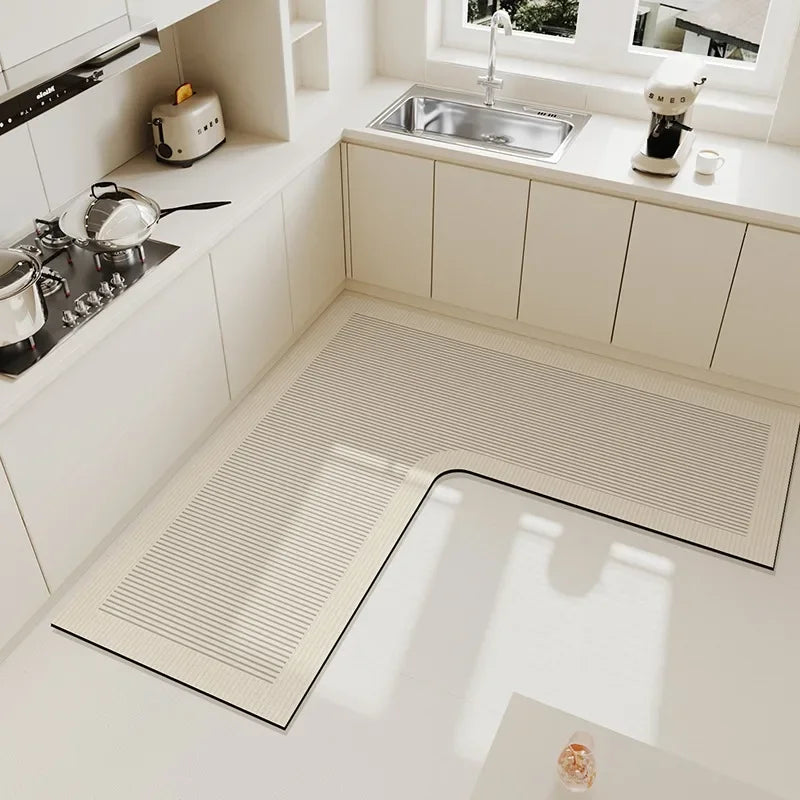 Une cuisine moderne aux lignes épurées, avec un évier en acier inoxydable, des plans de travail lisses et un sol recouvert d'un tapis à rayures.