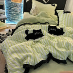 Détail de la broderie de chat rose sur la housse de couette rayée
