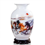 Un vase de décoration en porcelaine blanche avec une scène peinte de chevaux sauvages galopant dans la nature.