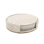 Une pile de sous-verres décoratifs avec des motifs dorés sur fond blanc, offrant une touche élégante et ornementale à la décoration d'intérieur.