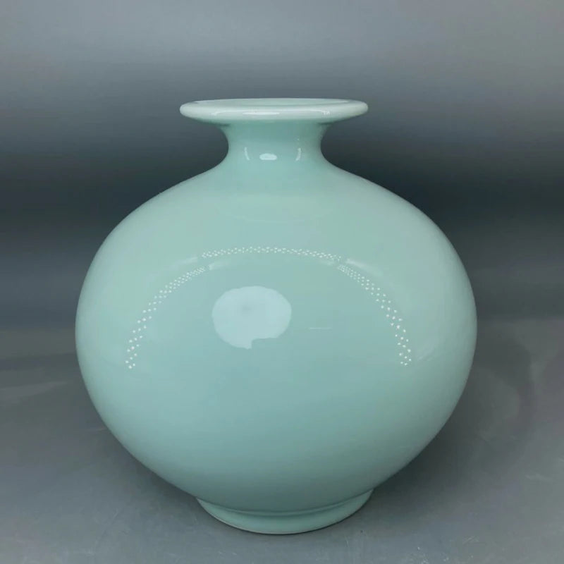 Vase en céramique bleu-vert opaque avec un motif circulaire et des points incrustés.