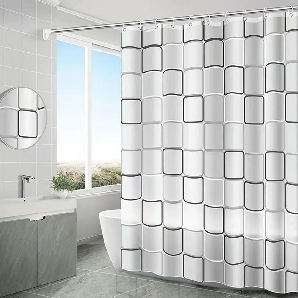 Salle de bain moderne au carrelage gris, avec un rideau de douche orné de carrés arrondis en relief, alternant des nuances de gris et de blanc. 