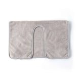 Un tapis de bain moelleux et gris clair avec une forme d'arc.