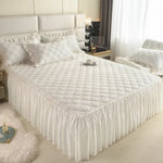 Jupe de lit matelassée gris clair sur un lit double
