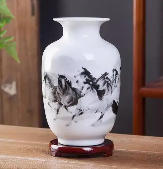 Vase ornemental blanc et noir avec motif de chevaux galopants, sur un support en bois.