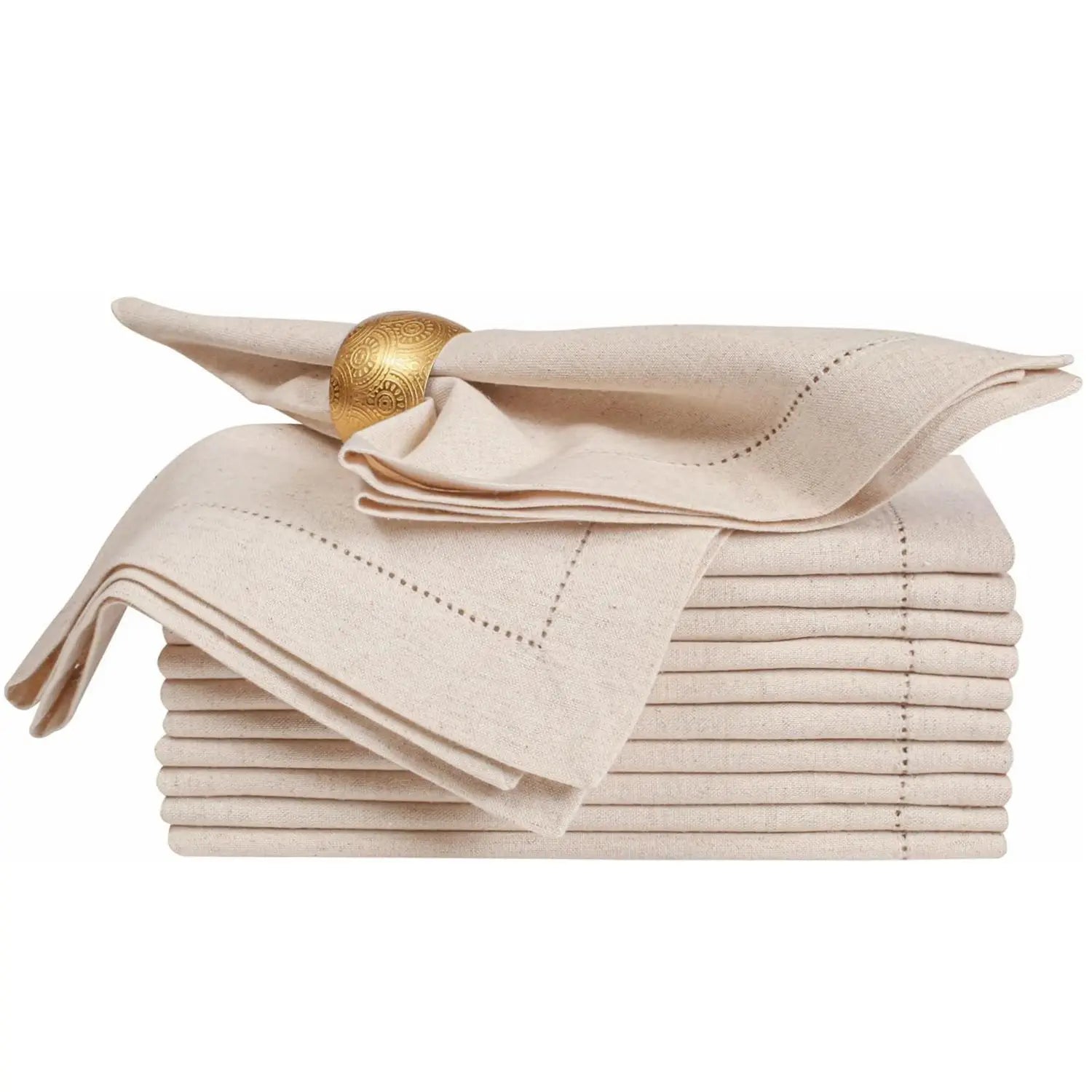Serviettes de table en lin beige avec boucle décorative dorée, empilement soigné sur une surface blanche.