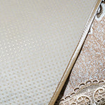 Texture en pointillés légers sur un support beige délicat, avec un motif décoratif délicat sur le côté.