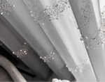 Rideau voilage gris clair avec décor perlé sur fenêtre style français.