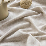 Image montrant une belle étoffe beige légèrement texturée, accompagnée d'une théière élégante et d'une pelote de fil couleur naturelle. Idéal pour la décoration intérieure, l'artisanat ou le design textile. Transformez votre espace de vie avec cette touche de style raffinée et naturelle.