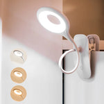 Lampe de chevet à pince blanche sur table de nuit