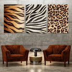 Des toiles décoratives avec des motifs de peau d'animaux comme le tigre, la zèbre et le léopard, complétées par deux fauteuils en velours marron dans une ambiance moderne et chaleureuse.