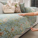 Un lit muni d'une couverture et de coussins aux motifs floraux délicats et de couleurs pastel, avec un sac en filet beige posé à côté, créant une atmosphère relaxante et harmonieuse dans cette pièce.