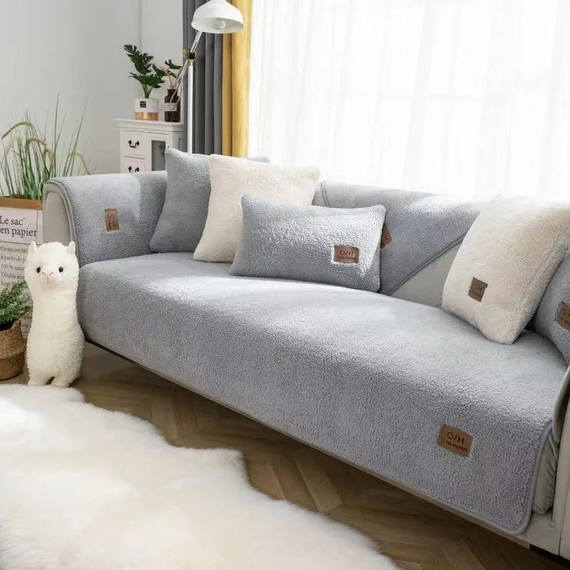 Un canapé gris confortable avec des coussins moelleux et un animal en peluche blanc dans un intérieur lumineux et apaisant.