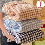 Une pile de couvertures chaudes à carreaux de différentes couleurs, prêtes à réchauffer confortablement.