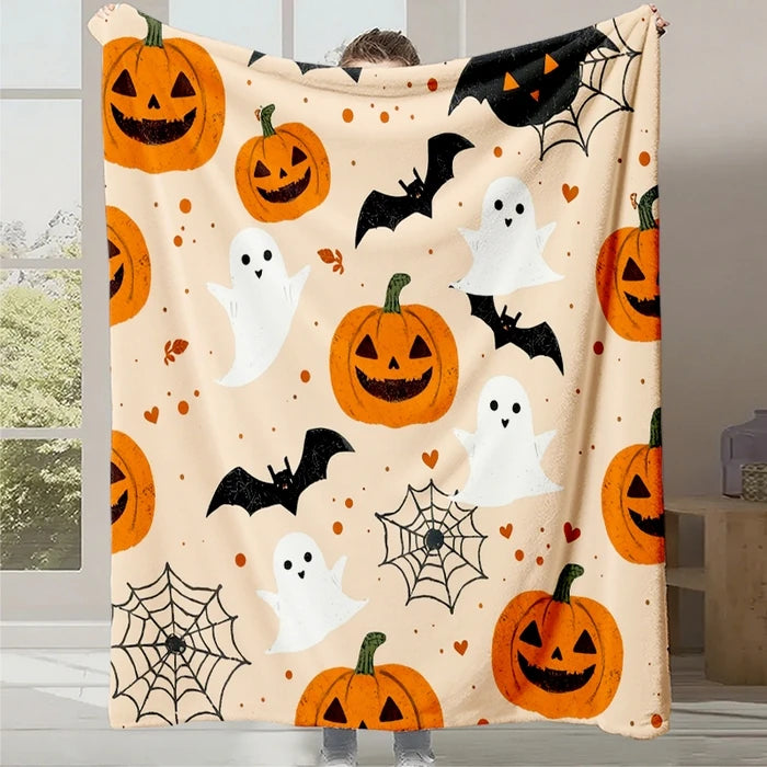 Couverture décorée de citrouilles jack-o'-lanterne, de fantômes et de chauves-souris, créant une ambiance festive pour l'Halloween.