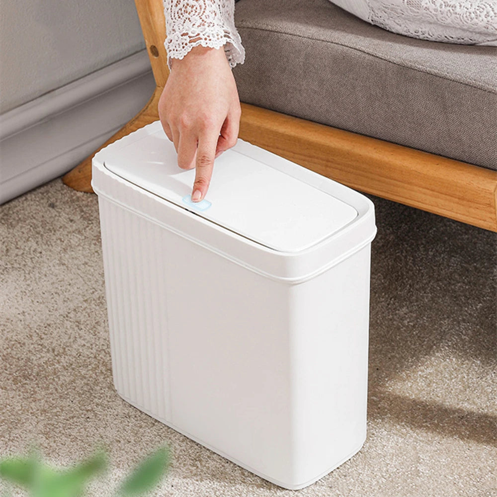 Poubelle étroite rectangulaire blanche avec brosse de toilette dans une salle de bain moderne