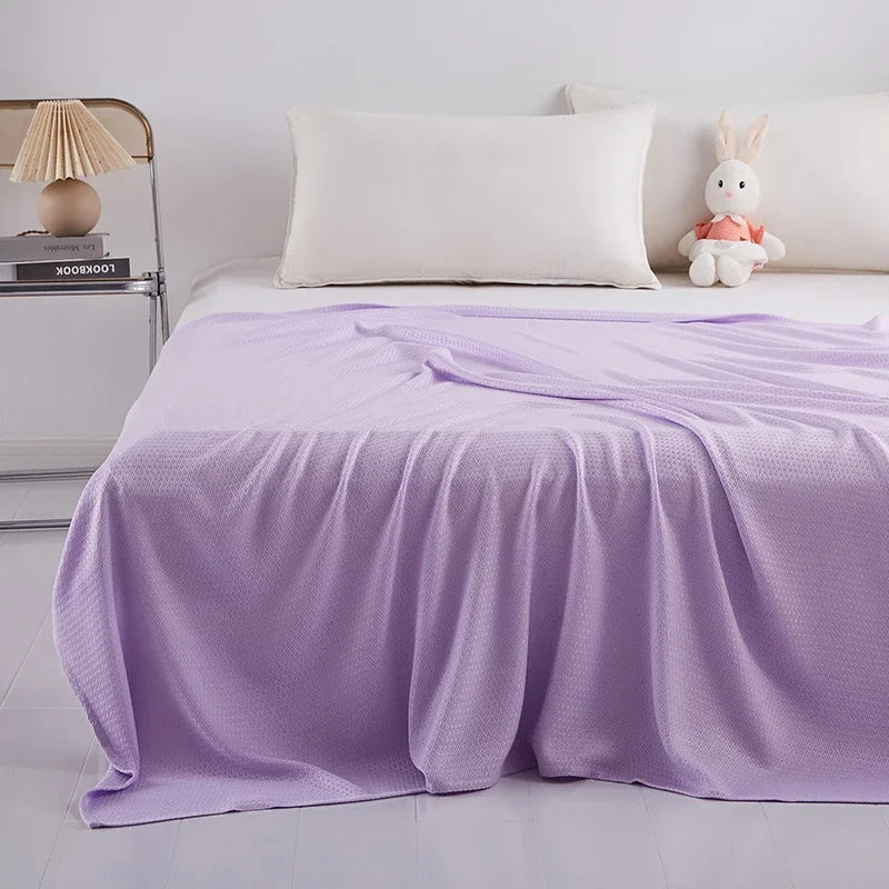 Lit douillet avec couverture moelleuse et peluche décorative, créant une ambiance relaxante.