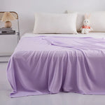 Lit douillet avec couverture moelleuse et peluche décorative, créant une ambiance relaxante.