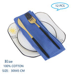 Ensemble de 12 serviettes de table bleues en coton de 30 x 45 cm, comprenant une fourchette et un couteau dorés sur une assiette blanche.