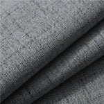 Gros plan sur un tissu gris en polyester effet lin, à la trame visible et à la texture épaisse, utilisé pour les rideaux.