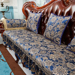 Un canapé en cuir brun richement orné de coussins et d'une courtepointe en tissu bleu et doré, créant une ambiance élégante et luxueuse.