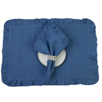 Un dessous de plat bleu avec un napperon en tissu et un nœud décoratif orné de strass.