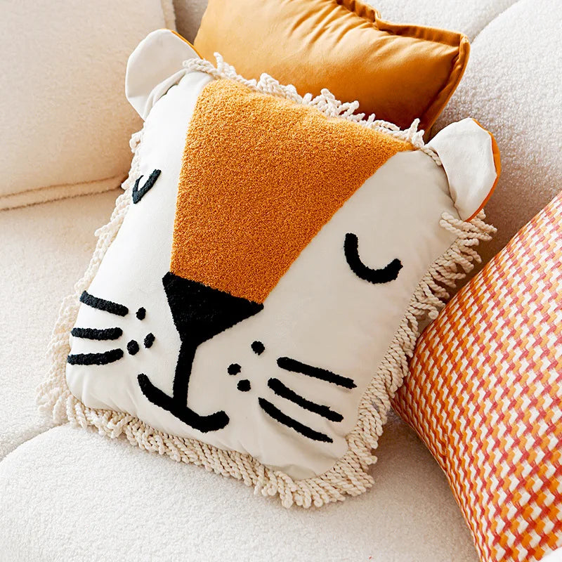 Un coussin décoratif en forme de tête de chat orange et blanc, orné de détails expressifs, ajoute une touche de douceur et de charme à l'espace.