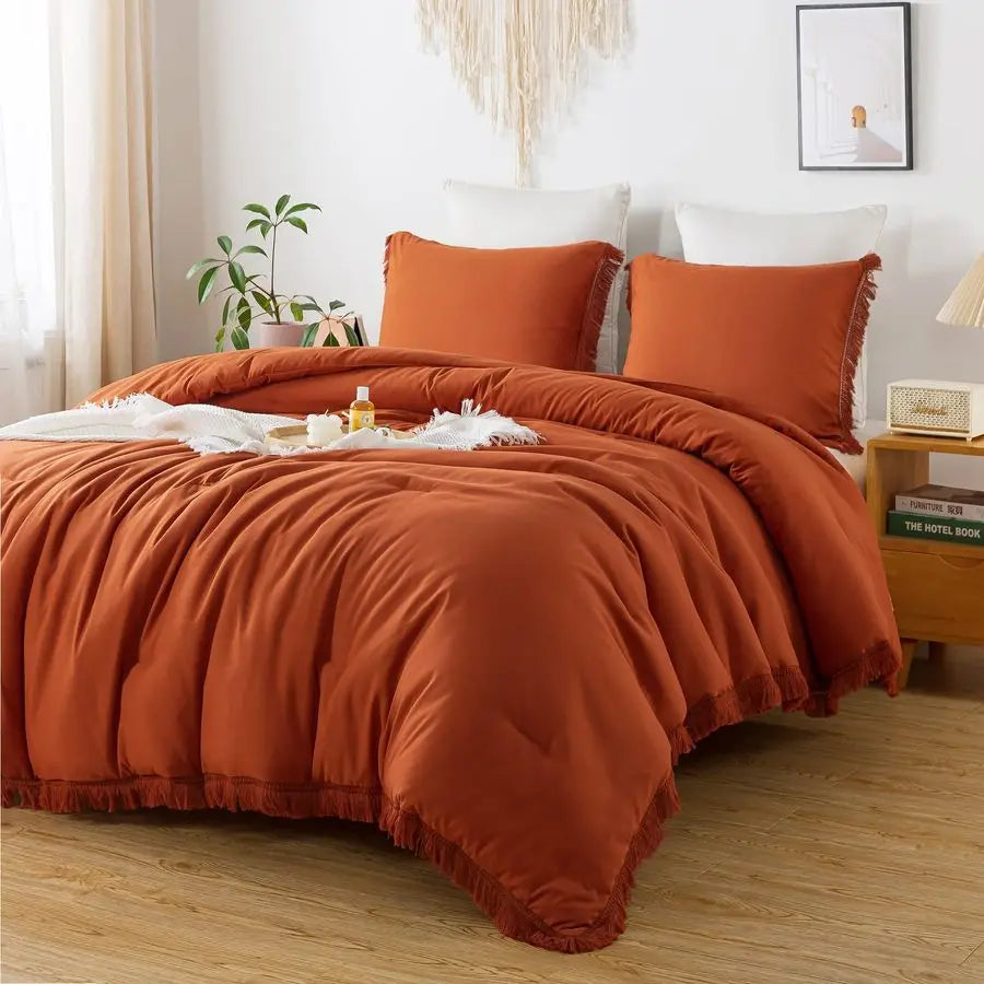 Parure de lit king size orange brûlé avec pompons boho sur un lit