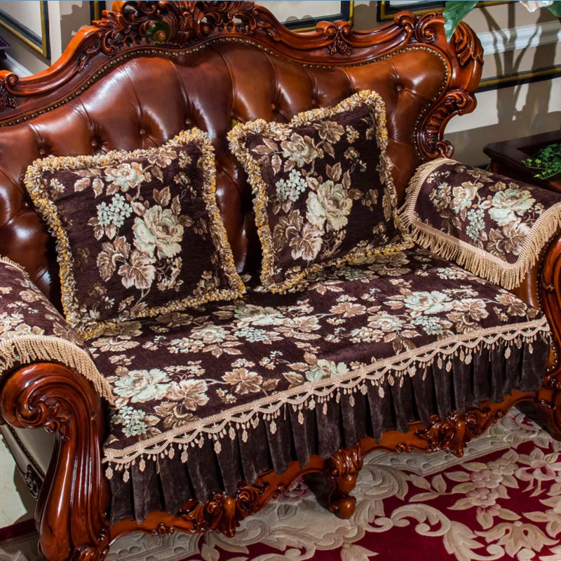 Un canapé en cuir brun richement décoré de coussins et de nappes à motifs floraux, créant une atmosphère luxueuse et élégante dans une pièce.