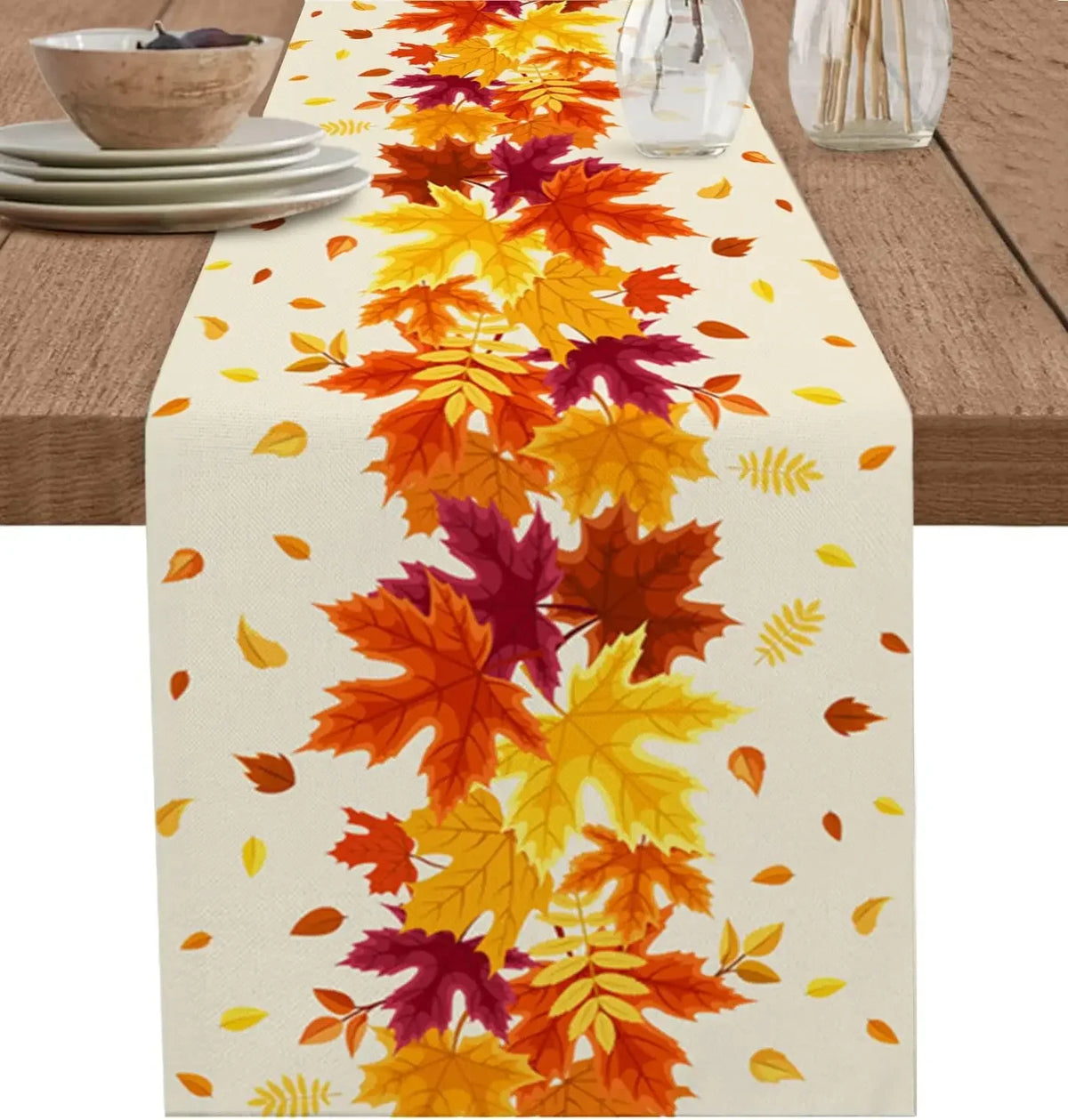 Cette image présente un chemin de table recouvert de feuilles d'automne colorées, notamment des tons de rouge, d'orange et de jaune, évoquant la beauté de la saison automnale.