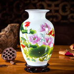 Vase décoratif orné de fleurs et de feuilles de lotus épanouis sur un fond blanc, créant une scène paisible et élégante.