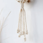 Composition déco avec plusieurs porte-plantes muraux en macramé